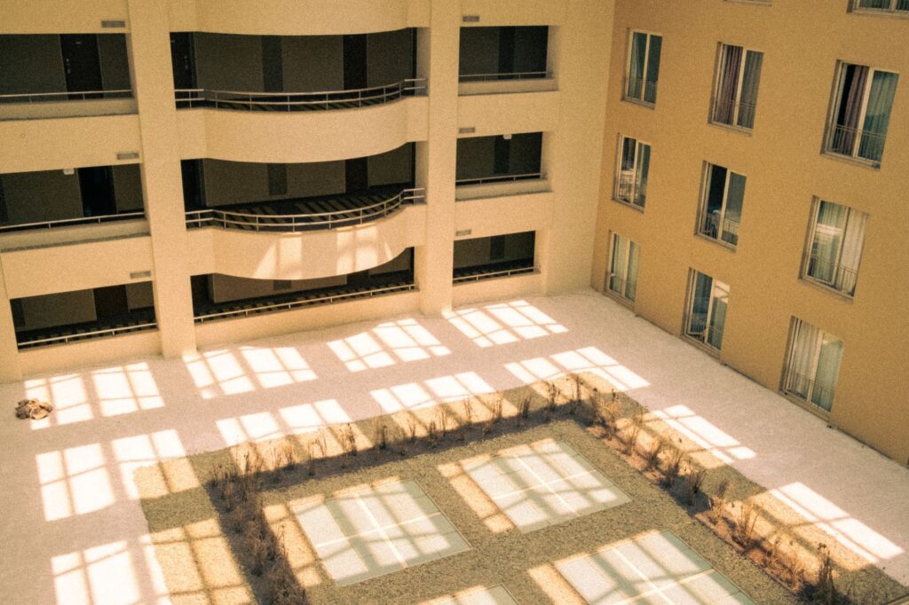 Patio interior de un edificio moderno con sombras geométricas.